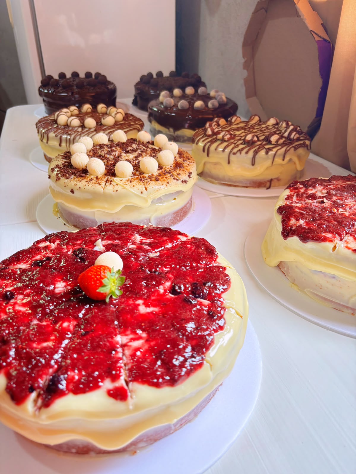 Mesa repleta de bolos do Festival: frutas vermelhas, chocolate e ninho