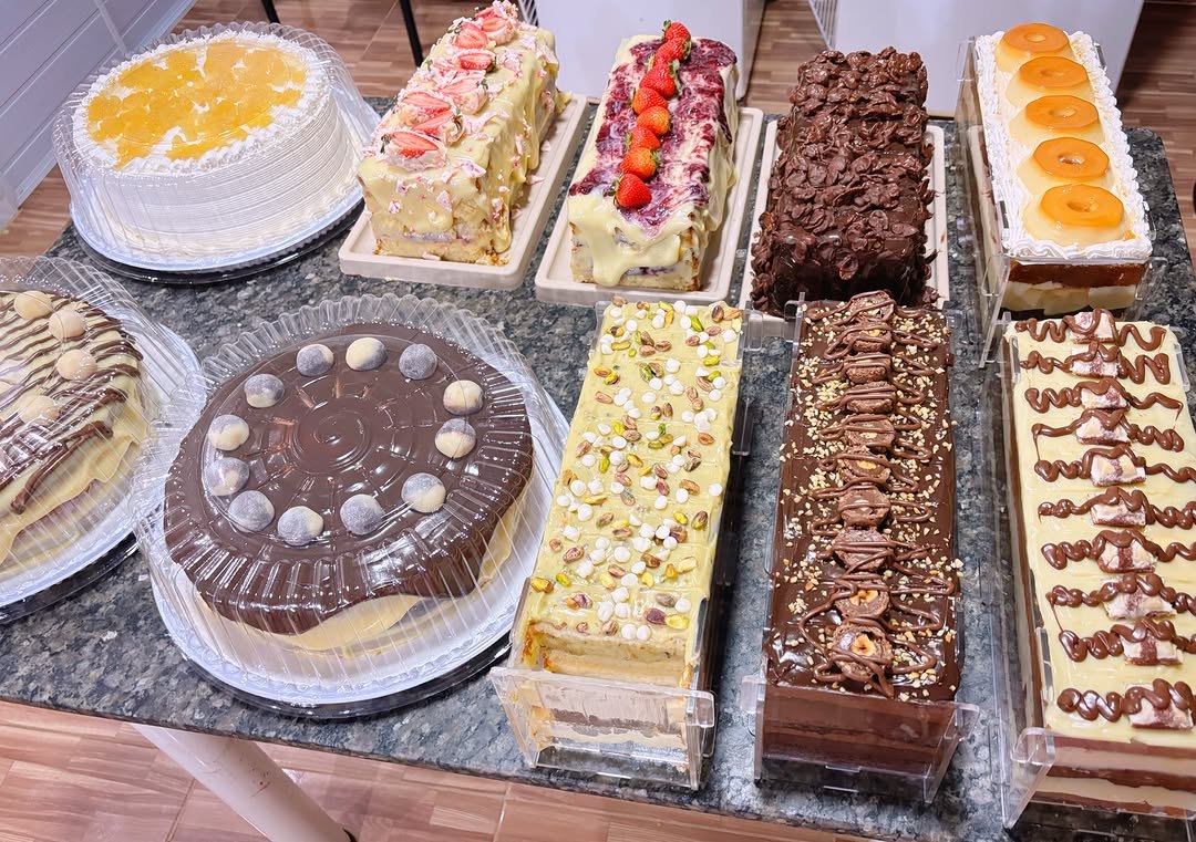 Mesa com tortas da Leyde Bolos: morango, frutas vermelhas, chocolate crocante, pistache, Ferrero e Kinder